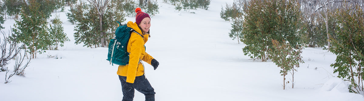 Chloe snowshoeing in Kosciuszko National Park wearing a bright yellow Fjallraven anorak