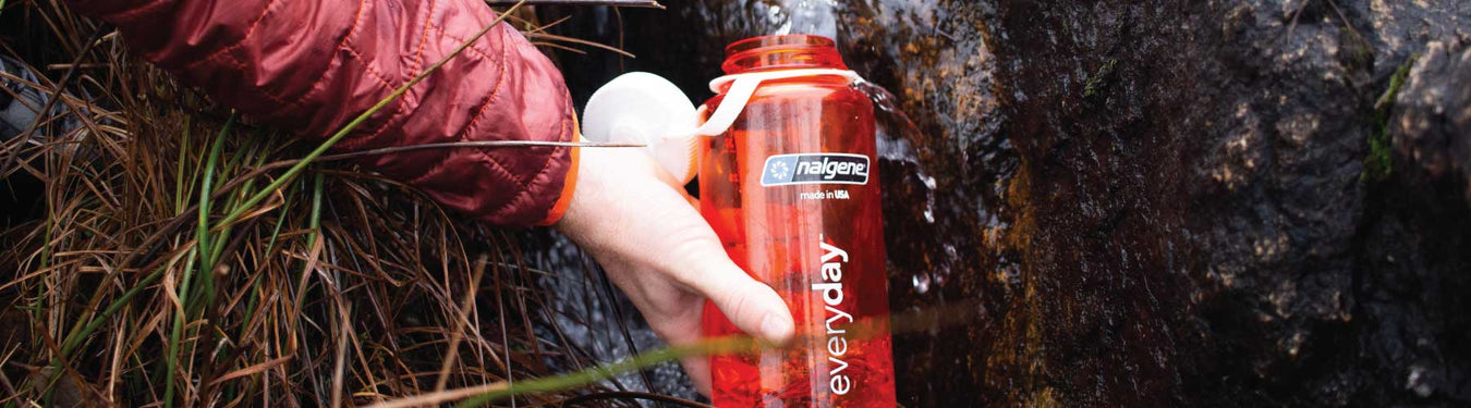 Filling up a Nalgene bottle in a crystal clear high country stream
