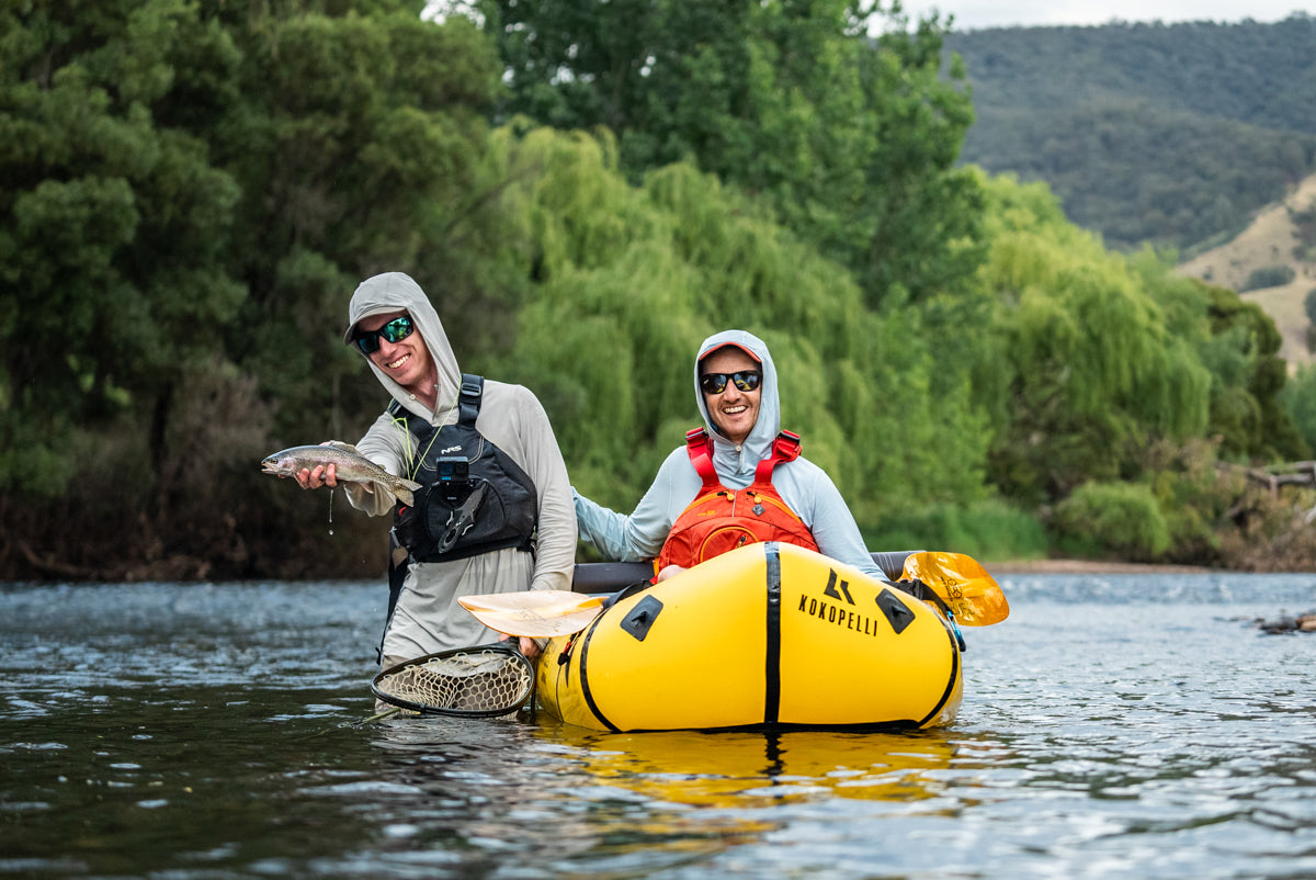 Pat holding a trout caught fly fishing from a packraft in the Tumut River 